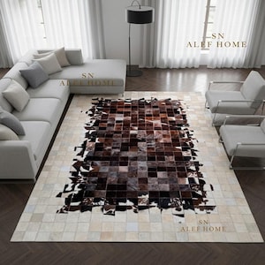 Peut inclure: Un tapis rectangulaire composé d'un assemblage de carreaux de peau de vache. Le centre présente des carreaux tachetés marron foncé, noirs et blancs, entourés d'une bordure de carreaux crème et beige clair. Le texte indique SN ALEF HOME.