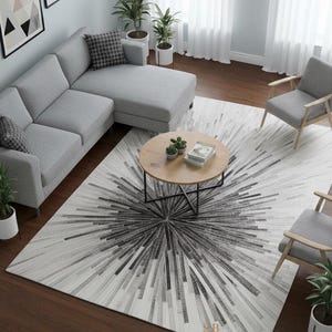 Può includere: Un moderno soggiorno con un divano angolare grigio, due poltrone grigie e un tavolino rotondo in legno. Un grande tappeto con un motivo a stella bianco e nero è centrato sul pavimento in legno scuro. Piante e opere d'arte completano lo spazio.