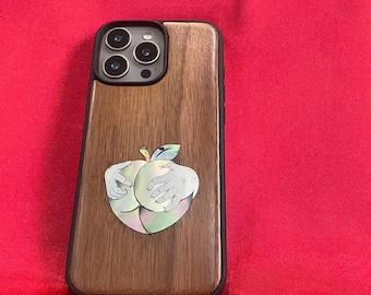 真珠貝と木材を使用したスマホケース。リンゴの形をした2つの様式化された臀部を象嵌したアート。光の当たり方や見る角度によって色が変わります。