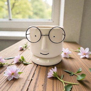 Maceta de cerámica con cara y vasos: un organizador de escritorio original
