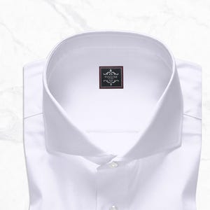 White cutaway collar dress shirt made from 100% Giza cotton poplin with French square cuffs, smooth back, no pocket, collar stays, 3-inch collar wings, and 1.5-inch collar band.
