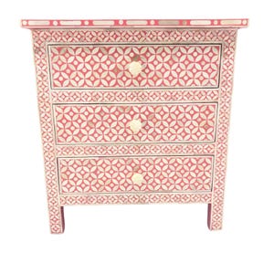 May include: A three-drawer chest of drawers with a geometric pattern in red and white. The chest has a rectangular shape with a decorative border and cream-colored knobs.