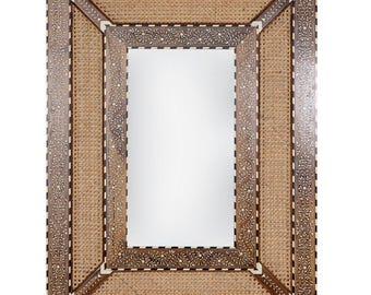 Puede incluir: Espejo rectangular con marco de madera decorativo. El marco presenta un centro de mimbre tejido, intrincados patrones florales y geométricos e incrustaciones blancas. El diseño del espejo es simétrico y ornamentado.