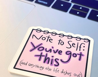 May include: A pink sticker with the text "Note to Self: You've got this (and anything else life dishes out)". The sticker is rectangular with a white border and a scalloped top edge, resting on a laptop keyboard.
