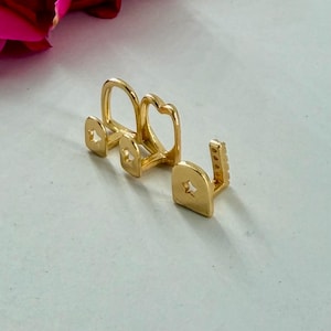 May include: A set of three gold-colored tooth caps, each featuring a small star-shaped cutout on the front surface. The caps are arranged in a row, showing a smooth, polished finish and a distinct U-shaped structure designed to fit over individual teeth.