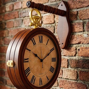 May include: A round, wooden wall clock with Roman numerals and a quartz movement. The clock is suspended from a decorative wooden arm with a gold-colored metal loop. The clock is mounted on a brick wall.