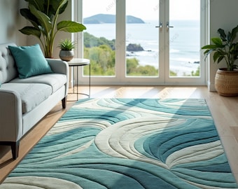 May include: A rectangular area rug with a wave-like pattern in shades of teal, blue, and off-white. The rug is placed on a hardwood floor in a room with a view of the ocean. The rug's design evokes a sense of water movement.