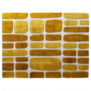 Può includere: Un tappeto rettangolare con un motivo a mattoni nei toni del giallo e del marrone su uno sfondo bianco. Il tappeto ha un aspetto strutturato, con il testo "The Rug Export" visibile. Questo tappeto è adatto per l'arredamento della casa.