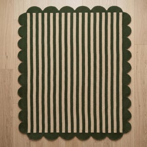 May include: A rectangular area rug featuring a pattern of vertical stripes in dark forest green and cream. The rug is finished with a decorative scalloped edge border in dark forest green that frames the entire striped design on all four sides.