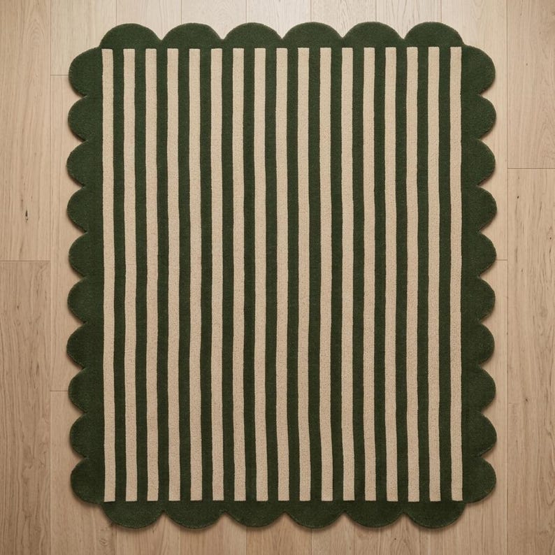 May include: A rectangular area rug featuring a pattern of vertical stripes in dark forest green and cream. The rug is finished with a decorative scalloped edge border in dark forest green that frames the entire striped design on all four sides.
