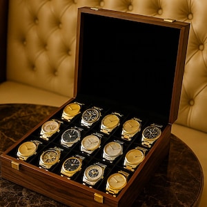 May include: A wooden watch box with a black interior, showcasing a collection of gold and silver wristwatches. The watches have various face designs and are arranged neatly in individual compartments. The box is open, revealing the timepieces.