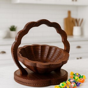 May include: A handcrafted wooden basket with a scalloped rim and handle. The basket is made of dark brown wood and sits on a round base. A small pile of colorful candies is in the foreground.