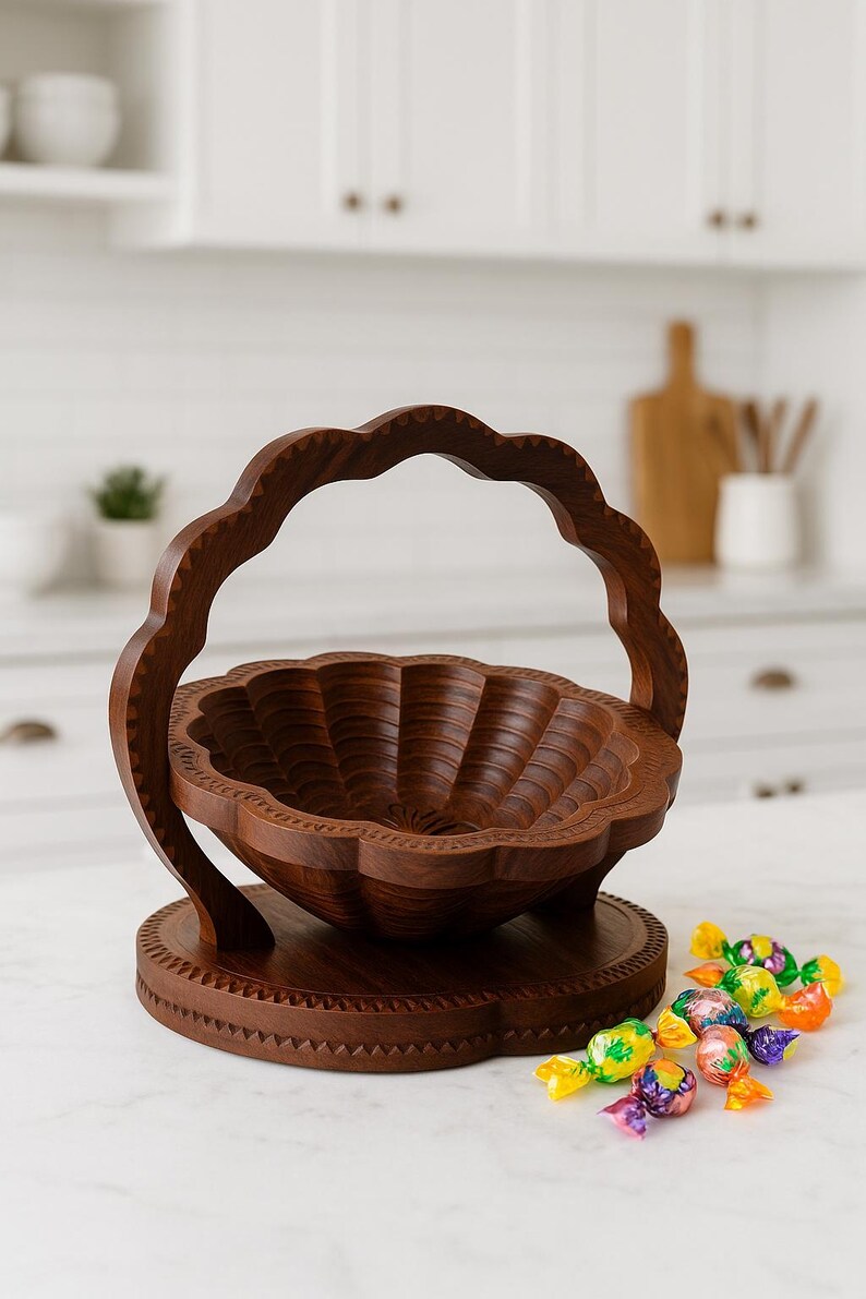May include: A handcrafted wooden basket with a scalloped rim and handle. The basket is made of dark brown wood and sits on a round base. A small pile of colorful candies is in the foreground.