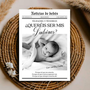 Puede incluir: Tarjeta de anuncio de bebé en blanco y negro con el titular "Noticias de bebés" y la pregunta "¿QUERÉIS SER MIS Padrinos?" Un bebé sonriente está en el centro. La tarjeta está sobre una estera tejida.