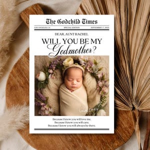 May include: A newspaper-style announcement with the headline "The Godchild Times" and the question "Will You Be My Godmother?" The announcement includes a photo of a swaddled baby surrounded by flowers. The text reads "Dear, Aunt Rachel" and "Love, Emely."