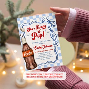 Puede incluir: Invitaci&oacute;n para baby shower con una ilustraci&oacute;n de botella de refresco vintage. La invitaci&oacute;n presenta el texto "She's Ready to Pop!" en rojo y azul, con detalles del evento y una solicitud de confirmaci&oacute;n.