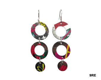May include: A pair of silver earrings with three circular charms. The charms are made of recycled materials and feature a colorful, abstract pattern.