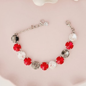 May include: A silver chain bracelet with alternating red, clear, and gray crystal stones.
