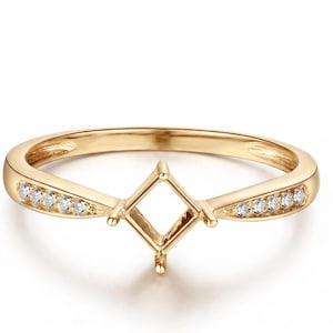 Puede incluir: Un anillo de oro con un engaste central vacío en forma de diamante diseñado para sostener una piedra preciosa. La banda está decorada con cinco pequeñas piedras redondas y claras incrustadas a cada lado, hacia el soporte central de cuatro garras.