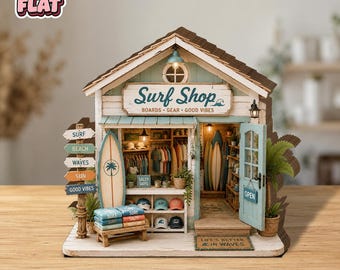 May include: A miniature wooden surf shop model featuring a sign that reads Surf Shop BOARDS GEAR GOOD VIBES. The structure includes a light blue door with an OPEN sign, a surfboard, stacks of folded shirts, hats, and a mat reading LIFE'S BETTER IN WAVES.