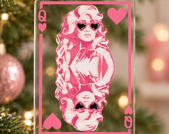 May include: A rectangular clear acrylic ornament shaped like a playing card featuring a pink and white graphic of a person with voluminous hair wearing heart-shaped sunglasses. The design includes the letter Q and heart symbols in the corners.