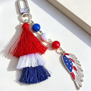 Llavero del 4 de julio, dije patriótico con borla para bolso, colgante del Día de la Independencia con la bandera estadounidense, corazón, estrella y alas.