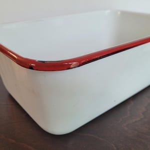 Vintage white enamelware baking pan with red rim, rectangular enamel roasting dish