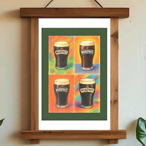 Op de afbeelding: Een ingelijste print met vier glazen Murphy's stout, elk op een andere gekleurde achtergrond. Het kunstwerk wordt gepresenteerd in een houten lijst, wat een rustieke toets toevoegt aan de kleurrijke compositie.
