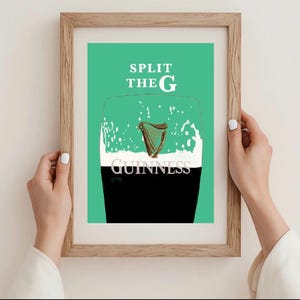 May include: A framed print featuring a pint of Guinness with a harp illustration. The text "SPLIT THE G" is above the glass, and "GUINNESS" is at the bottom. The background is a vibrant green.