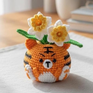 以下が含まれることがあります： 黒い持ち手と「But First, Coffee」のテキストが太字の黒でプリントされた白いセラミックマグ。マグカップは、居心地の良い環境を示唆するぼやけた背景に置かれています。