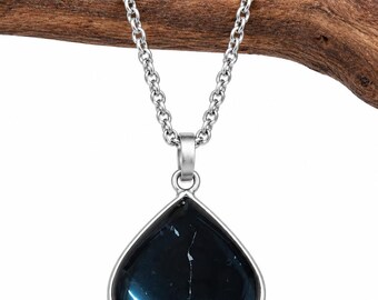 May include: A teardrop-shaped pendant necklace featuring a polished, dark blue stone with subtle white veining, encased in a smooth silver-toned metal setting. The pendant hangs from a matching silver-toned link chain, showcasing a clean design.