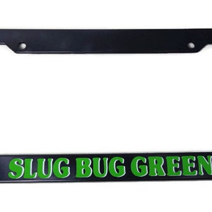 Puede incluir: Marco de matrícula de plástico negro con texto verde que dice "SLUG BUG GREEN".