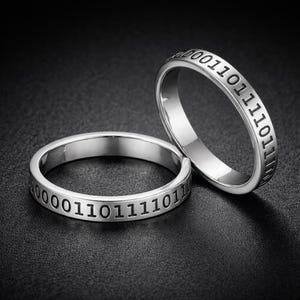 Anillo de plata personalizado con mensaje binario grabado.