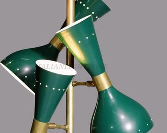 May include: A mid-century modern floor lamp with four green cone-shaped shades. Each shade has white dotted accents and is attached to a brass-colored stem. The lamp is a stylish lighting fixture.