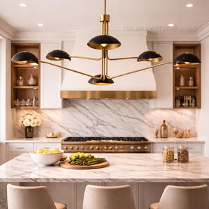 Pode incluir: Uma cozinha moderna com um lustre dourado e preto de seis luzes. A ilha da cozinha tem uma bancada de m&aacute;rmore e tr&ecirc;s bancos de bar bege. O texto "ITALIAN LIGHT ZONE" &eacute; vis&iacute;vel.