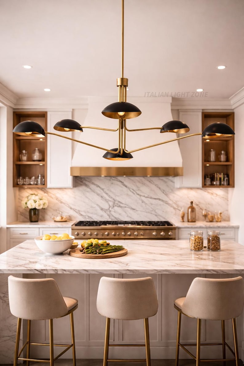 Pode incluir: Uma cozinha moderna com um lustre dourado e preto de seis luzes. A ilha da cozinha tem uma bancada de m&aacute;rmore e tr&ecirc;s bancos de bar bege. O texto "ITALIAN LIGHT ZONE" &eacute; vis&iacute;vel.