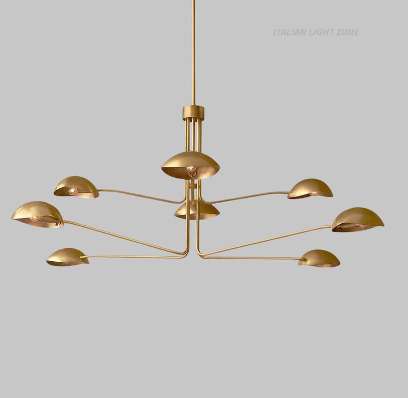 Pode incluir: Um lustre moderno em tom dourado com v&aacute;rios bra&ccedil;os curvos, cada um com uma lumin&aacute;ria em forma de c&uacute;pula. A lumin&aacute;ria tem uma coluna central e o texto "ITALIAN LIGHT ZONE".