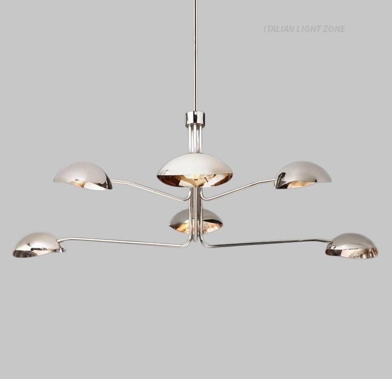 Pode incluir: Um candelabro moderno cromado com seis lumin&aacute;rias hemisf&eacute;ricas. As luzes est&atilde;o dispostas em bra&ccedil;os curvos que se estendem a partir de um centro. O texto "ITALIAN LIGHT ZONE" &eacute; vis&iacute;vel no canto superior direito.