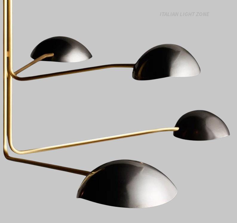 Pode incluir: Candeeiro de teto moderno com acabamento em lat&atilde;o e quatro abajures pretos em forma de c&uacute;pula. A lumin&aacute;ria tem um design minimalista com bra&ccedil;os curvos que se estendem de um suporte central. O texto "ITALIAN LIGHT ZONE" &eacute; vis&iacute;vel.