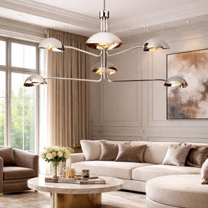 Pode incluir: Um lustre moderno com acabamento cromado polido e seis luzes em forma de c&uacute;pula. A lumin&aacute;ria pende sobre uma sala de estar com um sof&aacute; branco, uma mesa de centro redonda e uma decora&ccedil;&atilde;o em tons neutros. O texto "ITALIAN LIGHT ZONE" &eacute; vis&iacute;vel.