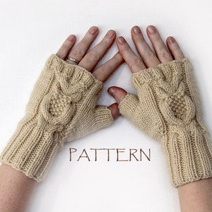 May include: Beige knitted fingerless gloves with an owl cable knit design. The gloves are made of soft yarn and have a ribbed cuff. The word "PATTERN" is written in brown ink.