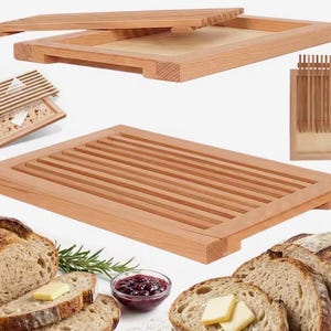 May include: A rectangular wooden bread cutting board featuring a removable slatted top tray that allows crumbs to fall into the base. The light-colored wood grain is visible throughout the structure, which is shown in multiple angles including a top-down view and a side perspective, accompanied by slices of bread, butter, and a small bowl of jam.