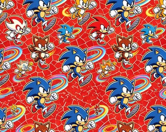 Tela 100% algodón con estampado de Sonic the Hedgehog sobre fondo rojo, disponible por medio metro.