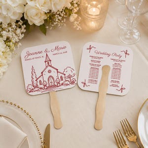 May include: Two white wedding fans with red text and illustrations. One fan features a church drawing and the names "Joanne & Mario" with the date "March 24, 2028." The other fan lists wedding party roles.