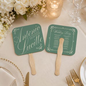 May include: Two teal wedding fans with wooden handles. One fan displays the names "Antonio" and "Lucille" with the date "09.29.2029". The other fan has the words "Wedding Party" and a list of names. Floral accents frame the text.