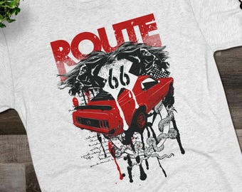 May include: A light gray t-shirt featuring a graphic design with the word "ROUTE" in red, along with the number "66" and a red car. The design also includes black and white illustrations and text.