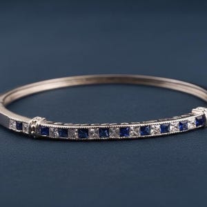 Brazalete rígido de zafiro y diamantes - Brazalete articulado de plata chapada en oro de 14 quilates con gema azul de talla princesa.