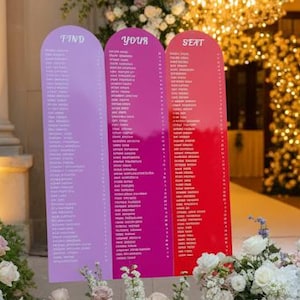 May include: A wedding reception scene with floral decorations and seating charts. Three colourful signs read "Find Your Seat". White flowers and greenery decorate the entrance and aisle. The scene is lit with soft lighting.