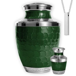 May include: A green urn with a textured surface and silver accents. A smaller matching urn and a silver pendant necklace are also shown. The urns have a decorative pattern around the top and bottom.
