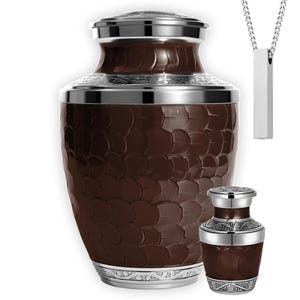 May include: A white ceramic mug with a black handle and the text "But First, Coffee" in a black, handwritten-style font. The mug is on a white surface.